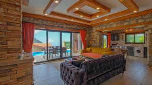 a living room with a couch and a table at VİLLA VAVEYLA in Oludeniz