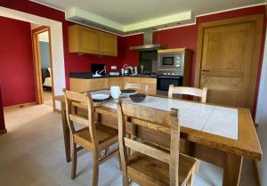 een keuken met een grote houten tafel en stoelen bij En Vert & En Pause in Thimister