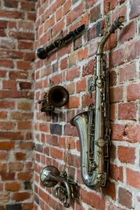 een saxofoon is bevestigd aan een stenen muur bij OLD TOWN Studio Święty Wojciech street - Poznań by Renters in Poznań