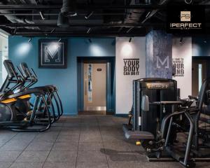 a gym with cardio equipment and a blue wall at The Mercian Luxury Apartments Birmingham City Centre - Your Perfect Stay Apart hotels- 24 Hour Gym Rooftop Terrace Cinema Room in Birmingham