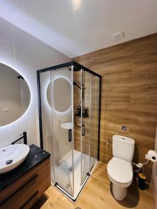 a bathroom with a toilet and a glass shower at Apartamentos TriBeca Centro II in Albacete