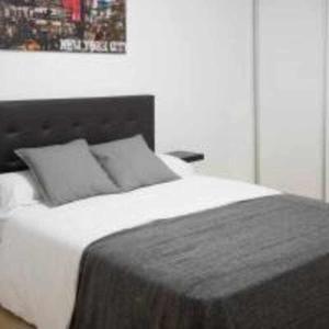 マドリードにあるA Unos Pasos Para Gran Via Madrid Xxlのベッドルーム1室(壁に絵が描かれた白いベッド1台付)