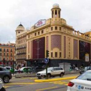 duży budynek z samochodami zaparkowanymi przed nim w obiekcie A Unos Pasos Para Gran Via Madrid Xxl w Madrycie