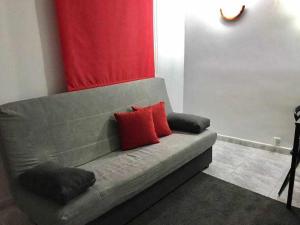 マドリードにあるAgradable apartamento en zona Malasaña Madridの赤い枕2つ付きのソファ
