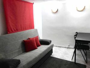 マドリードにあるAgradable apartamento en zona Malasaña Madridの赤い枕2つ付きのソファ