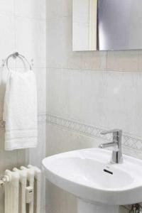 uma casa de banho branca com um lavatório e um espelho em A Unos Pasos a Gran Via Madrid Xl em Madri