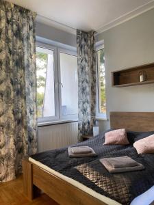 1 dormitorio con 1 cama grande y 2 ventanas en Bella Rossi en Jastrzębia Góra