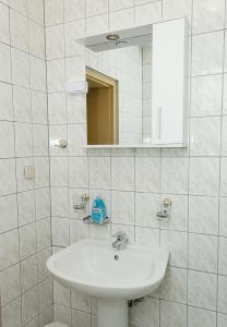 Un baño blanco con lavabo y espejo. en Two Identical Designer 2BD Flats with Sea View in Balchik by Flat Mаnager, en Balchik