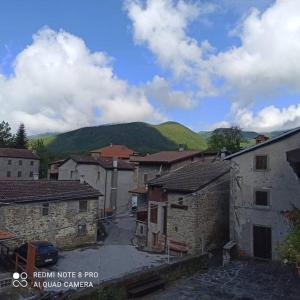 uma vista para uma aldeia com montanhas ao fundo em Casa immersa nella natura em Capanne di Sillano