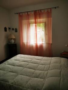 ein Schlafzimmer mit einem großen Bett und einem Fenster in der Unterkunft Casa immersa nella natura in Capanne di Sillano