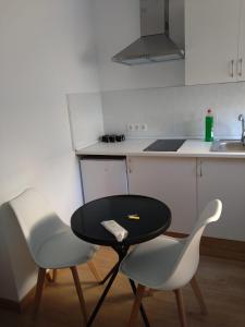 a kitchen with two chairs and a table and a sink at Appartment as a Service - Lo Mejor en Malaga Centro - Look no Further and Just Book in Málaga