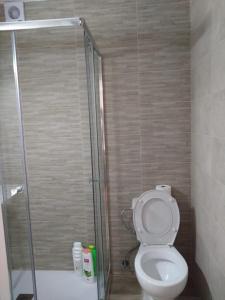a bathroom with a toilet and a glass shower stall at Appartment as a Service - Lo Mejor en Malaga Centro - Look no Further and Just Book in Málaga