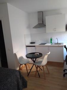 a kitchen with a table and two chairs and a sink at Appartment as a Service - Lo Mejor en Malaga Centro - Look no Further and Just Book in Málaga +7 photos