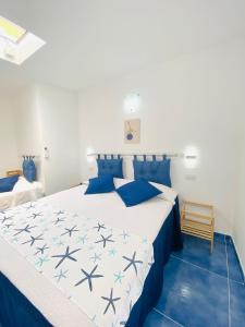 a bedroom with a large bed with blue pillows at Casa Leo in Anacapri