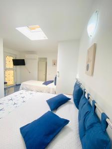 una grande camera da letto con due letti con cuscini blu di Casa Leo ad Anacapri