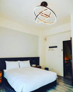 a bedroom with a large white bed and a chandelier at 安平包棟民宿 - 尋雨 - 台南民宿Ktv影音室限包棟使用 in Tainan