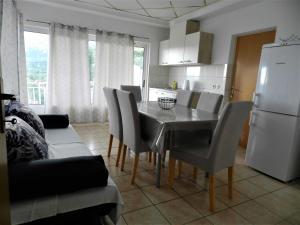 cocina con mesa, sillas y nevera blanca en Apartments Lea, en Orebić
