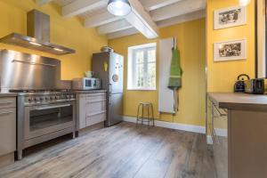 a kitchen with yellow walls and stainless steel appliances at La Garenne in Bretenière