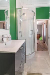 uma casa de banho com uma cabina de duche em vidro e um lavatório. em La Garenne em Bretenière
