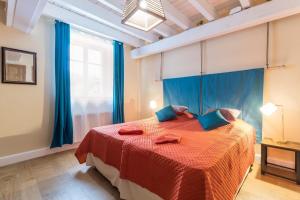 um quarto com uma cama com cortinas azuis e uma janela em La Garenne em Bretenière