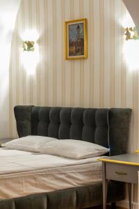 a bedroom with a bed and a picture on the wall at Sia Boutique Aparthotel in Sibiu