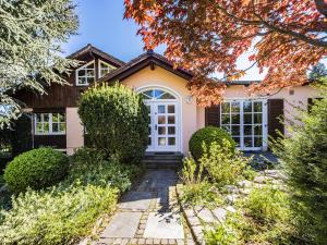 una casa con una puerta blanca y árboles en Homely Stay in a romantic lodging with sauna&gym, en Münsing