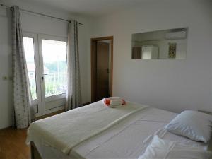 1 dormitorio con cama con espejo y ventana en Apartments Lea, en Orebić