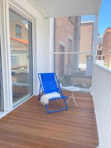 uma cadeira de baloiço azul sentada numa varanda em #2800ourhome 202 em Mechelen
