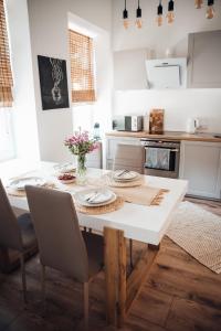 cocina con mesa blanca y sillas en Stylish and cozy old town apartment, en Võru