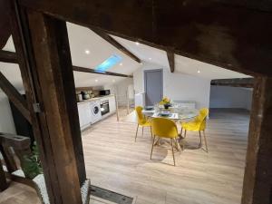 a kitchen and dining room with a table and yellow chairs at Kiss Cool - Loft en centre ville in Saint-Dizier