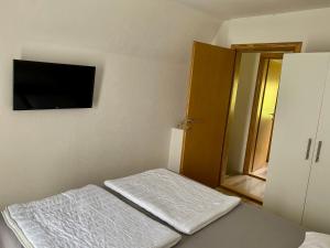 um quarto com uma cama e uma televisão de ecrã plano em Vikendica sa bazenom em Višegrad