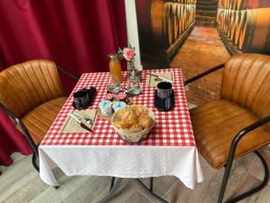 une table avec un chiffon de table rouge et blanc dans l'établissement Douce Halte, à Sautron