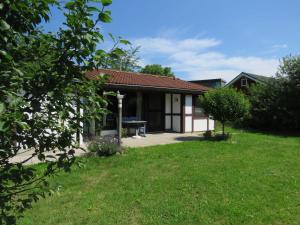 a house with a grassy yard in front of it at Ferienhaus Scout 48 im Feriendorf in Hollern-Twielenfleth