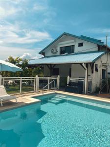 ein Haus mit einem Pool vor einem Haus in der Unterkunft Villa Stone pour 8 personnes, piscine chauffée, accès PMR, 5 étoiles in Sainte-Luce