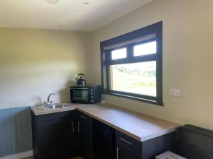 a kitchen with a counter and a sink and a window at Craigengillan Mini Lodge in Dalmellington