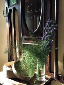 un jarrón de flores sentado en una mesa con un espejo en Trisileja en Puente Romano en Toñanes