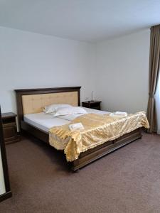 una camera da letto con un letto coperto di PENSIUNEA TEOMIR a Pojorîta