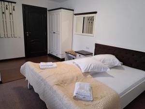 a bedroom with a bed with two towels on it at PENSIUNEA TEOMIR in Pojorâta