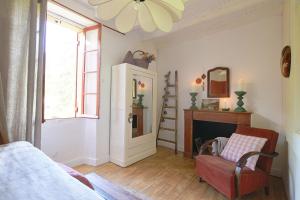 Una sala de estar con una silla y una chimenea. en La Maisonnette de La Jolie Vie, en Urval