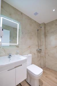 クサミルにあるAjlina Apartmentsのトイレ、洗面台、シャワー付きのバスルーム