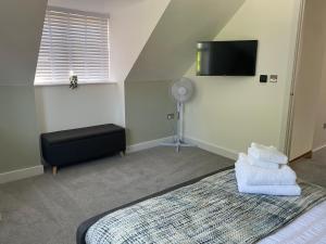 a bedroom with a bed and a flat screen tv at The Lodge at Crown Point, Entire Place, Private Secure Parking, EV Point, Brand new 