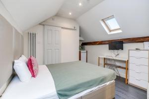 a bedroom with a bed and a desk in it at Quiet Double Studio Flat in London