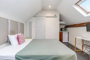 a bedroom with a large bed with a green blanket at Quiet Double Studio Flat in London