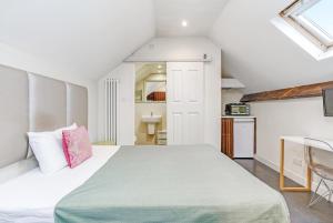 a bedroom with a large bed and a kitchen at Quiet Double Studio Flat in London