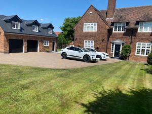 two cars parked in front of a brick house at The Lodge at Crown Point, Entire Place, Private Secure Parking, EV Point, Brand new in Hillmorton
