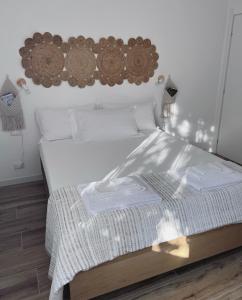 a bedroom with a white bed with a wooden headboard at Casa Amapola in Follonica