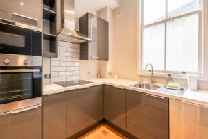 a kitchen with stainless steel appliances and a window at Canal Crescent Charm Flat with Stunning Views Little Venice in London