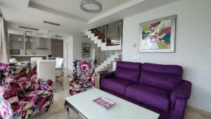 una sala de estar con un sofá púrpura y sillas en PARADISE LUXURY villa sea view, en Villajoyosa
