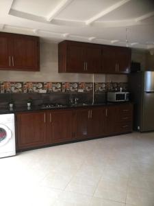 阿加迪爾的住宿－Chatif，厨房配有木制橱柜和白色的电器