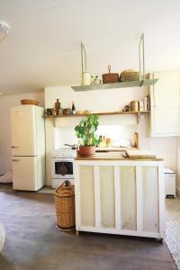 eine Küche mit einem Herd und einem weißen Kühlschrank in der Unterkunft La Maisonnette de La Jolie Vie in Urval
